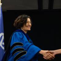 Fatma and student shaking hands